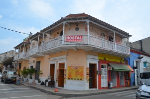 Coin de rue montrant une maison et ses balcons.