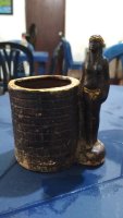 Petit pot avec une statue sur une table.