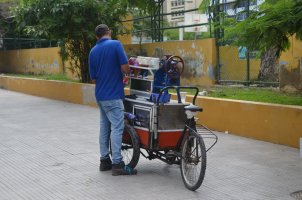 Homme auprès de son vélo cargo proposant des mets à manger.